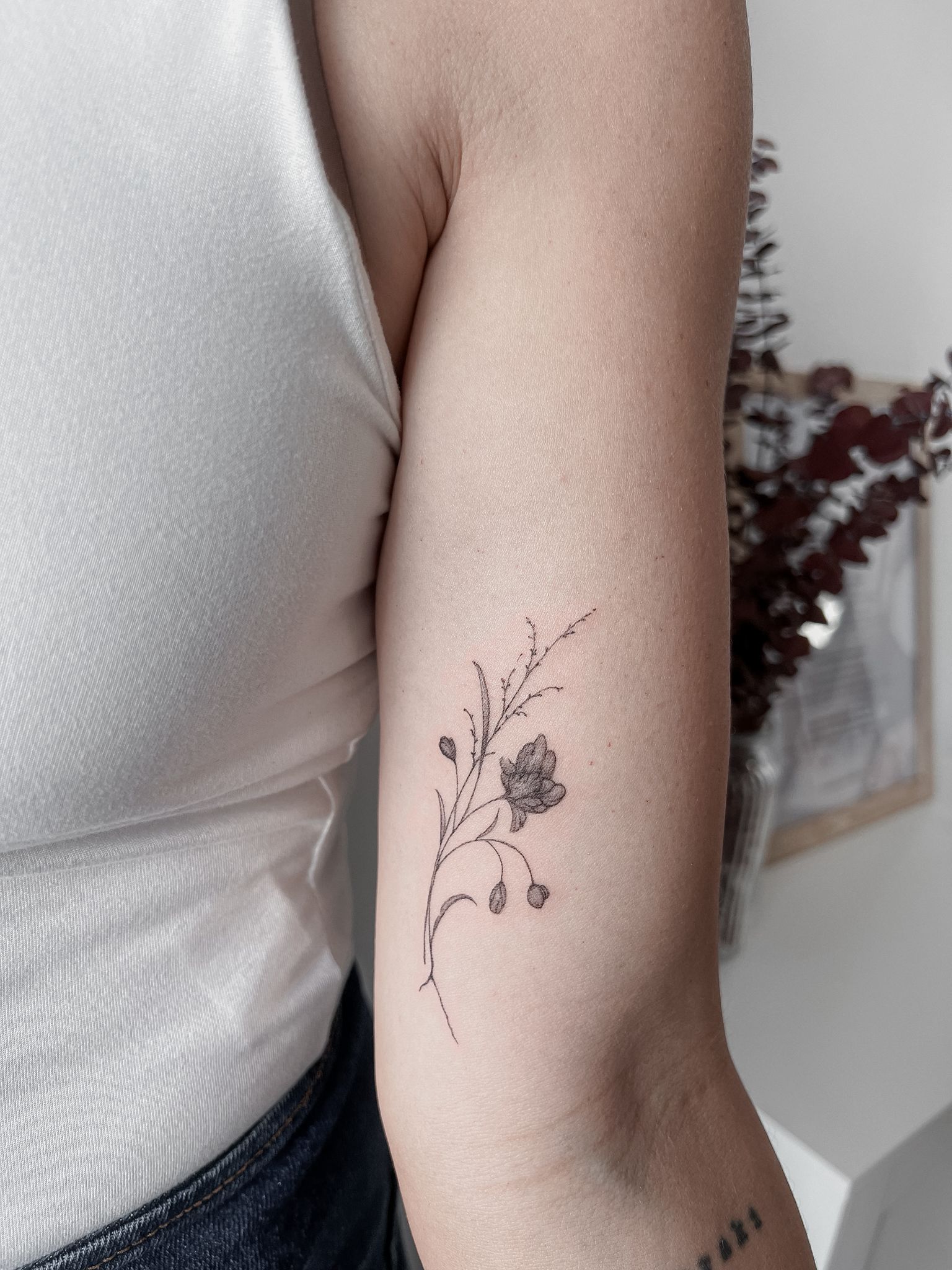 Tatuaje fine line de flores por Marta San